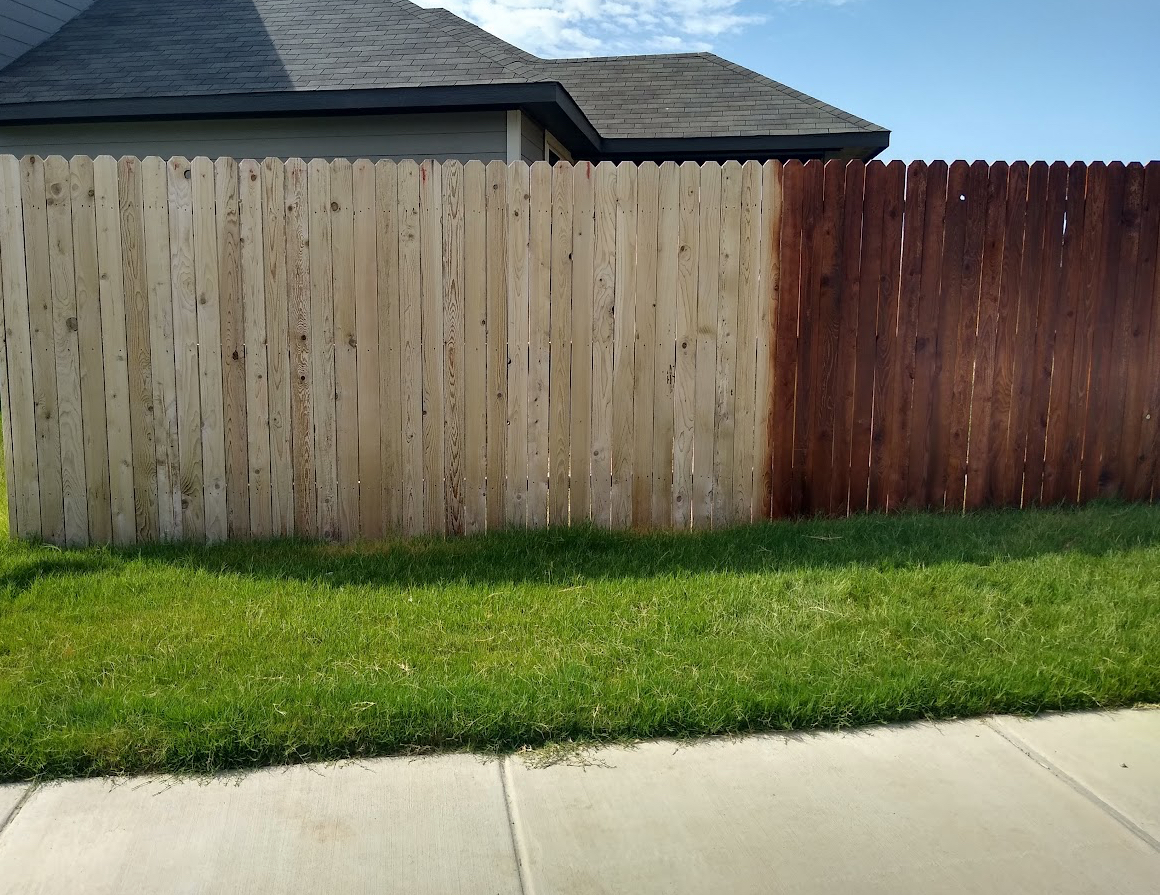 Privacy fence half raw wood, half finished in deep mahogany stain